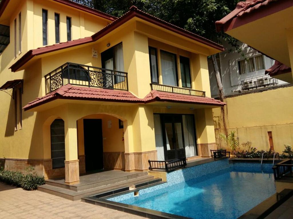 a house with a swimming pool in front of it at Lagoon Villa in Old Goa