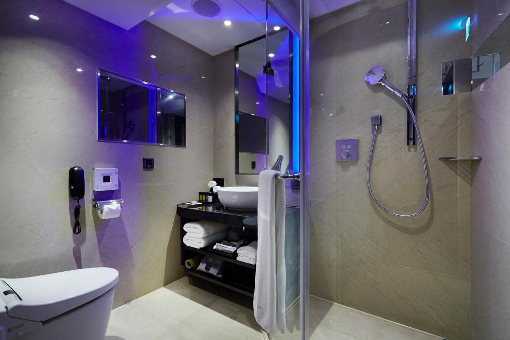 a bathroom with a shower and a toilet and a sink at The Tango Hotel Taipei FuHsing in Taipei