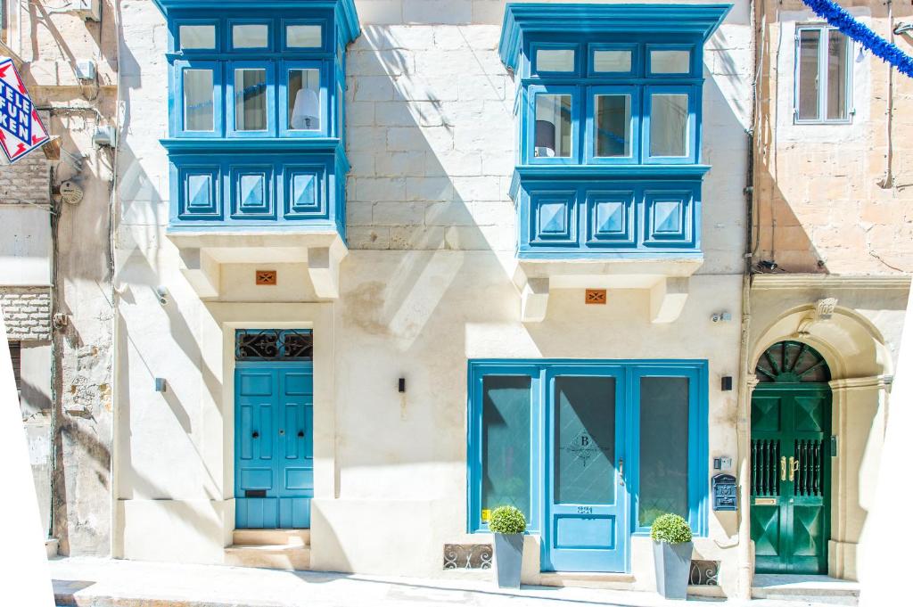 un edificio con ventanas azules y puertas azules en Backstage Boutique Music Themed Townhouse, en Sliema