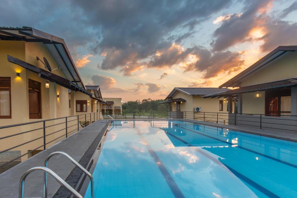 a resort pool with a sunset in the background at Sense Pavillion in Horana