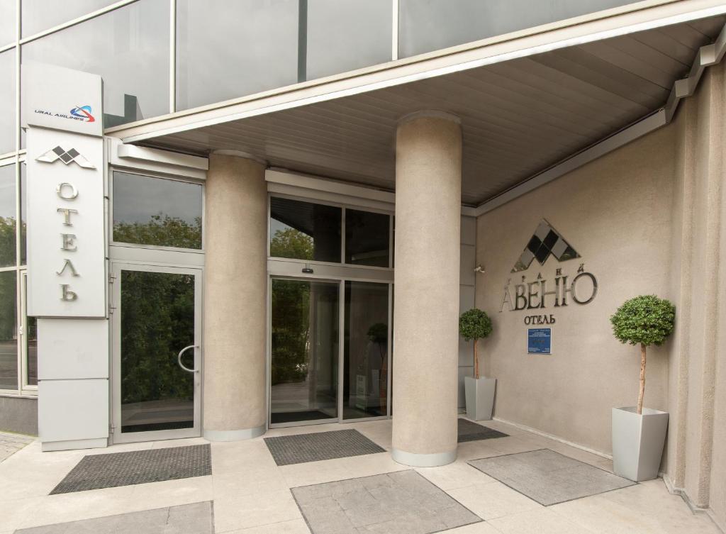 un bâtiment avec colonnes et un panneau devant lui dans l'établissement Grand Avenue by USTA Hotels, à Iekaterinbourg