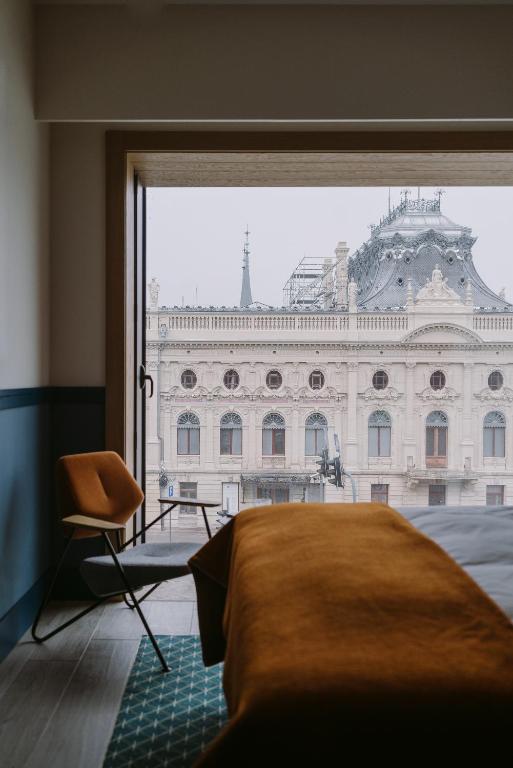 a bedroom with a view of a large building at PURO Łódź Centrum in Łódź