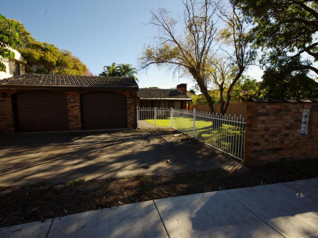 uma cerca em frente a uma casa com uma entrada em Fravent house em Toukley