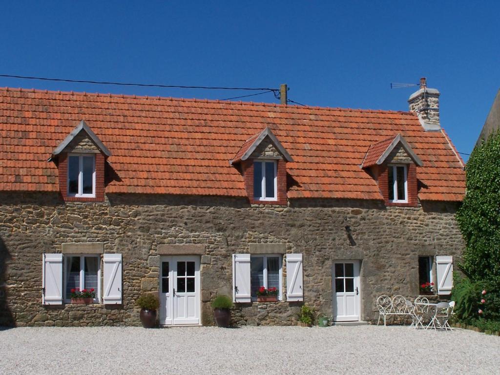 a large brick building with white doors and windows at Les deux caps in Carneville