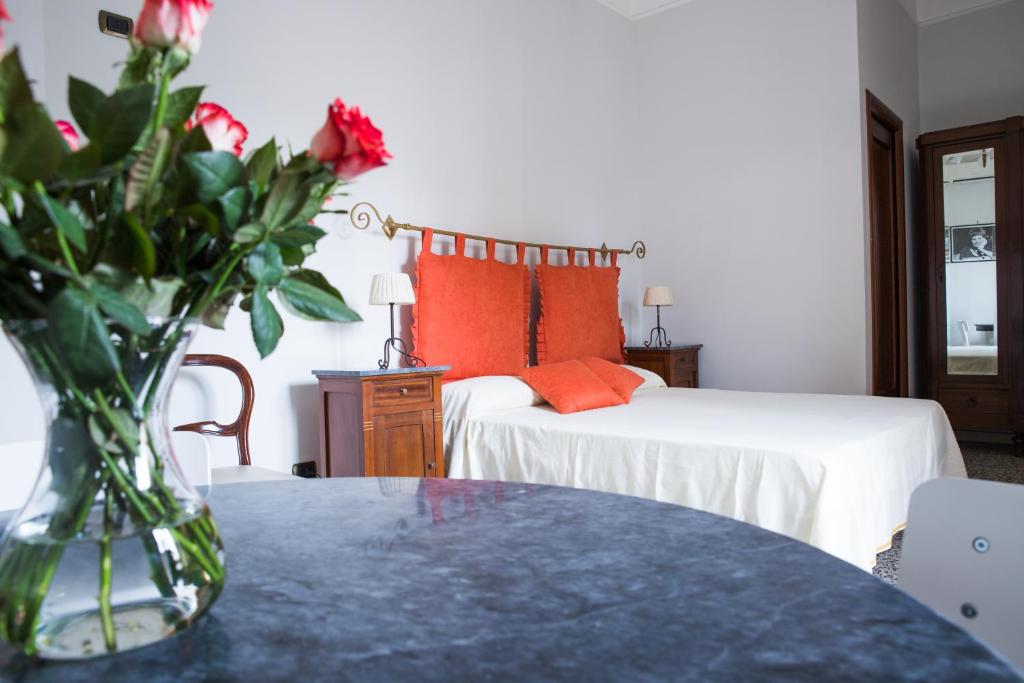 una camera con due letti e un vaso di fiori su un tavolo di Vittoria Guest House Battipaglia a Battipaglia