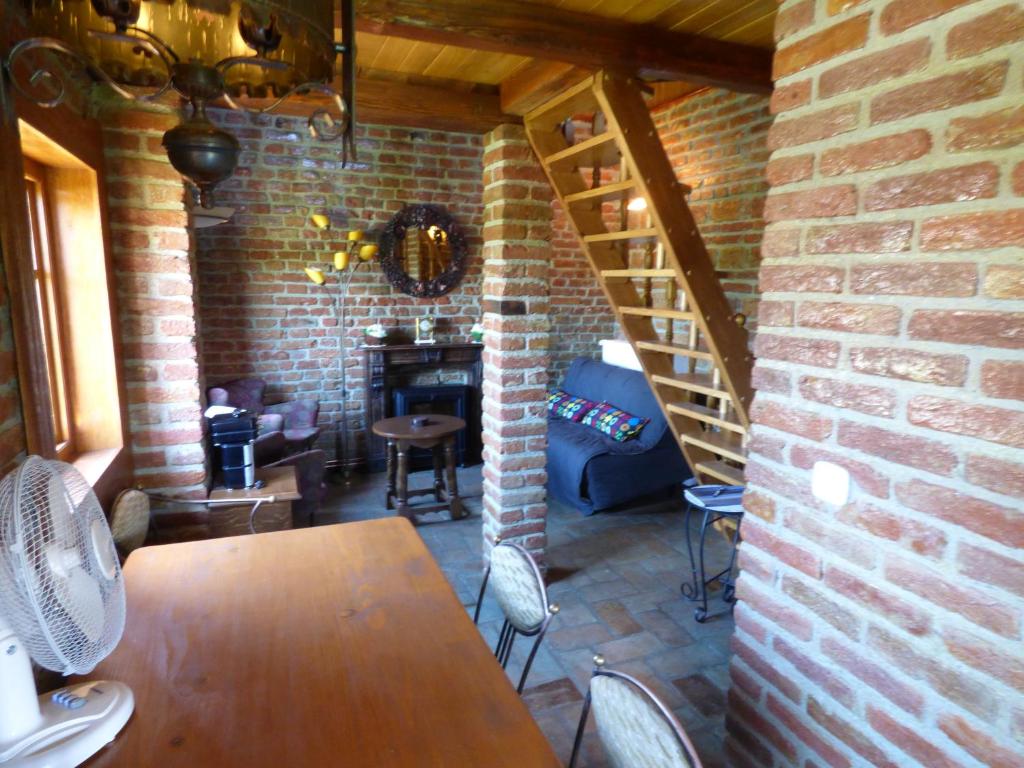 a patio with a table and chairs and a brick wall at Cottage Plavi Lav Potok in Potok