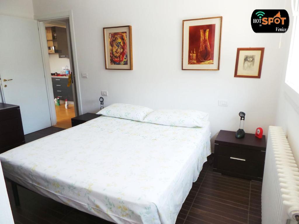 - une chambre avec un lit et deux photos sur le mur dans l'établissement Hotspot Venice Ca'Marcello 2000 Palace, à Mestre