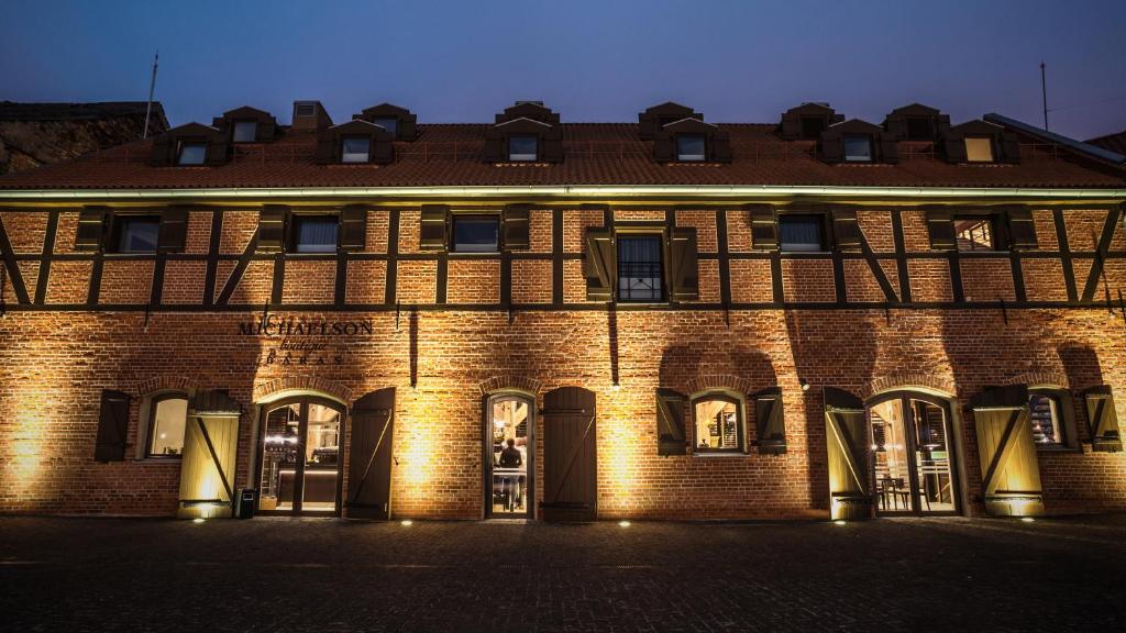 a large brick building with lights on the front at Michaelson Boutique Hotel in Klaipėda