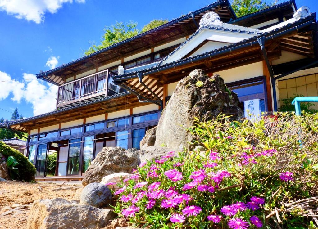 uma casa com algumas flores em frente em Matakitai em Ichinoseki