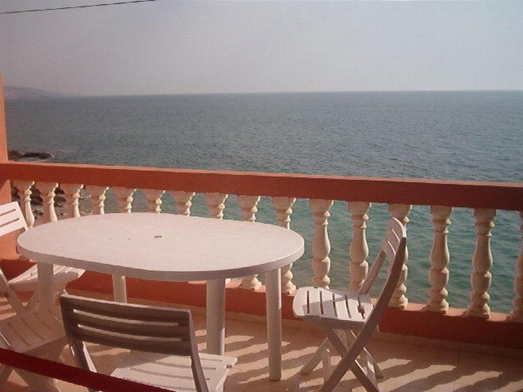 einen Tisch und Stühle auf einem Balkon mit Meerblick in der Unterkunft Surf Appartement Taghazout 6 in Taghazout