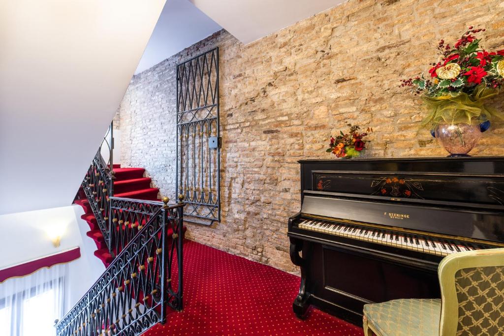 a piano in a room with a brick wall at A Tribute To Music Residenza in Venice
