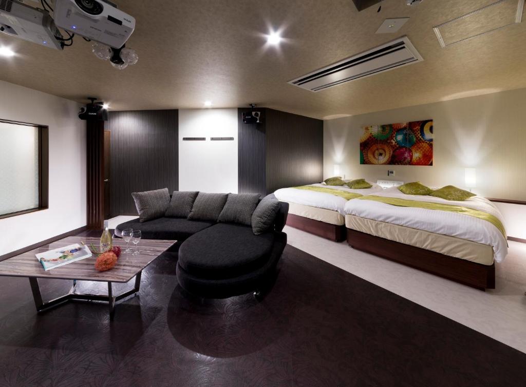 Habitación de hotel con cama, sofá y mesa en HOTEL BYAKKA, en Kagashima