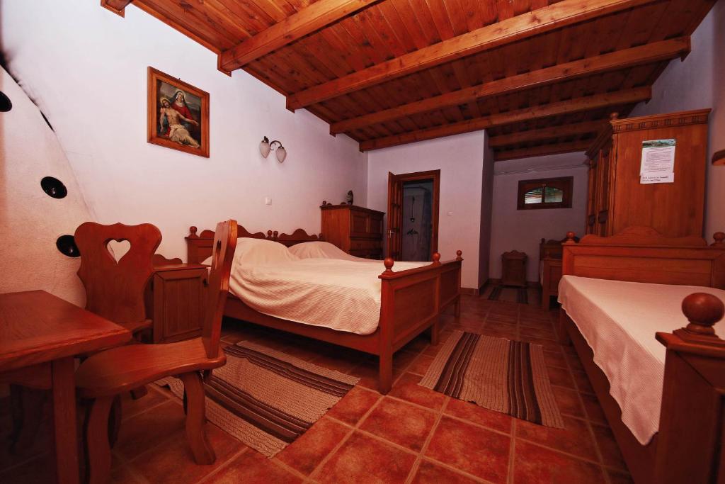 a bedroom with two beds and a table and a desk at Ócsárdi Tópanzió in Ócsárd
