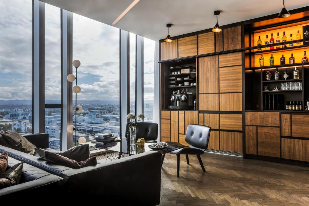 a living room with a couch and a bar with windows at Tower Suites Reykjavík in Reykjavík