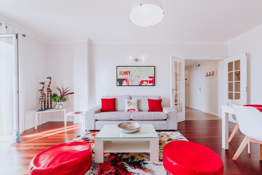 a living room with a couch and red chairs at Funchal Old Town Apartments 2.8 in Funchal