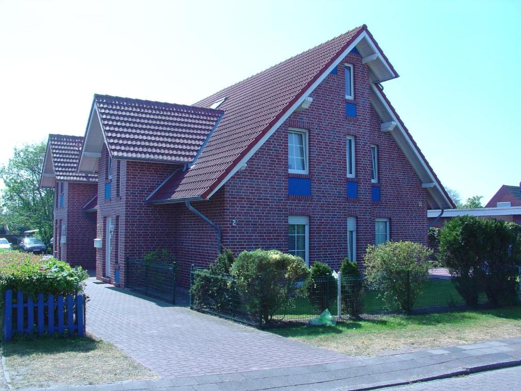 una casa de ladrillo rojo con techo de gambrel en Ferienwohnung Kiebitznest, en Borkum