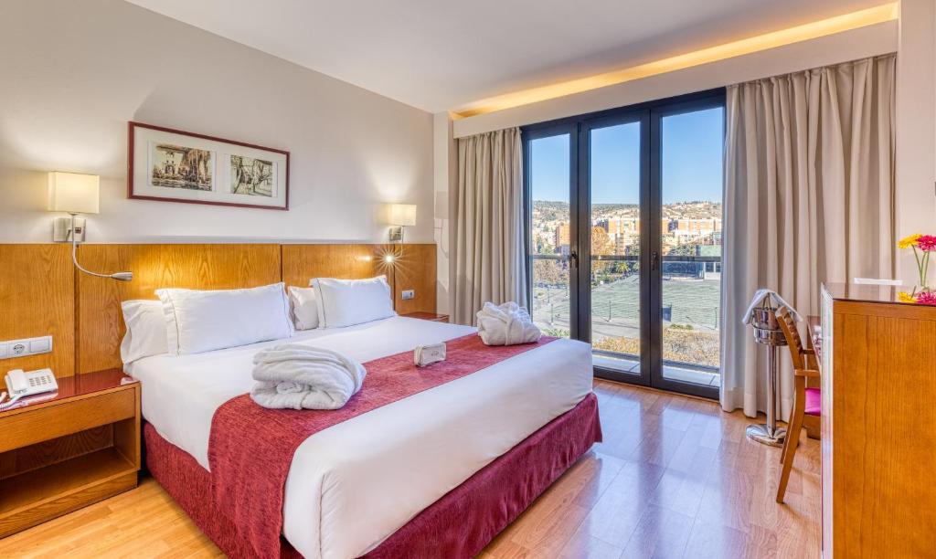 a hotel room with a bed and a large window at Senator Granada in Granada