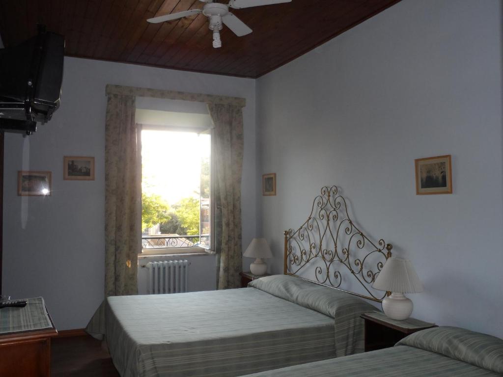 una camera da letto con due letti e una finestra di Albergo Lucia Pagnanelli a Castel Gandolfo