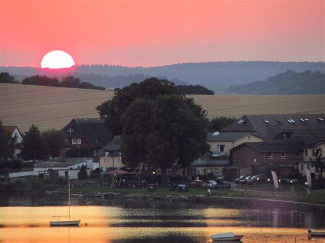 einen Sonnenuntergang über einer Stadt mit einem See und Häusern in der Unterkunft FeWo Lindenhof in Alt Reddevitz