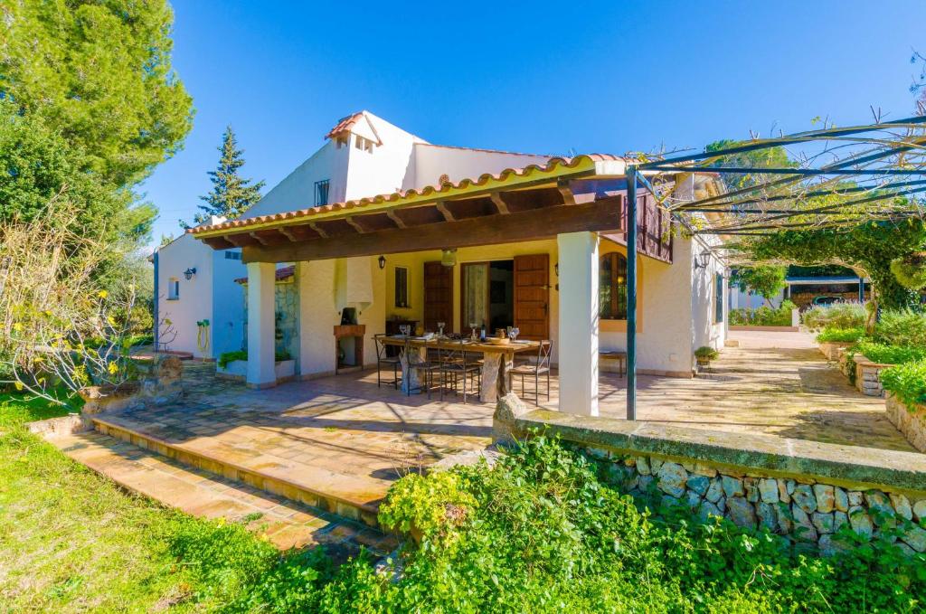 Casa blanca pequeña con terraza de madera en Can Capulla 8 en Ses Covetes