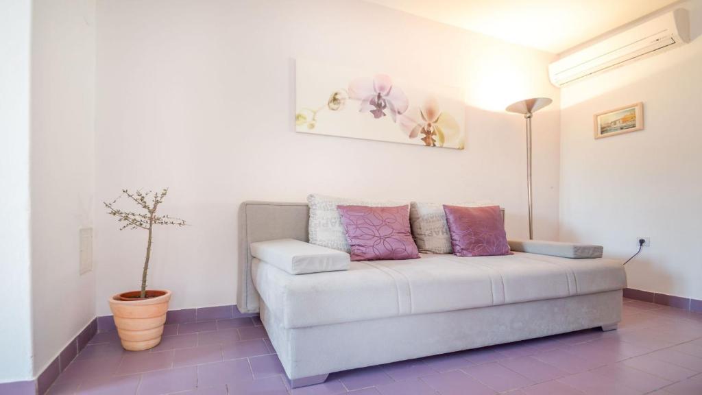 - un canapé blanc dans un salon avec une plante en pot dans l'établissement Apartment Medulin, à Medulin