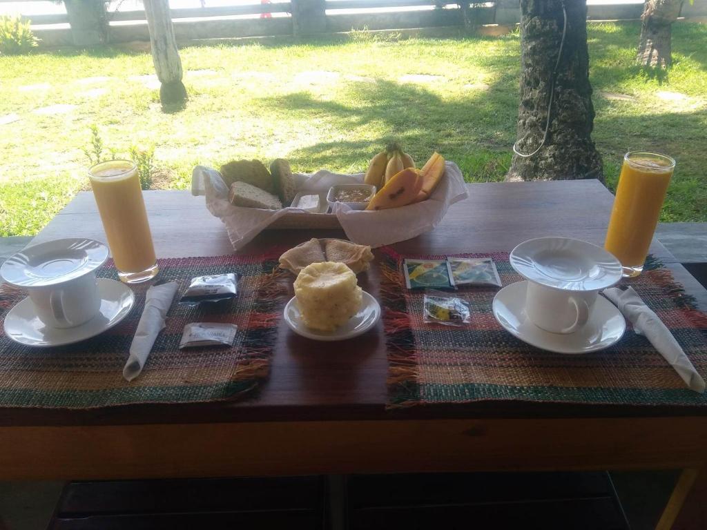 a table with a plate of food and a bowl of fruit at LE TRANSAT in Ambatoloaka
