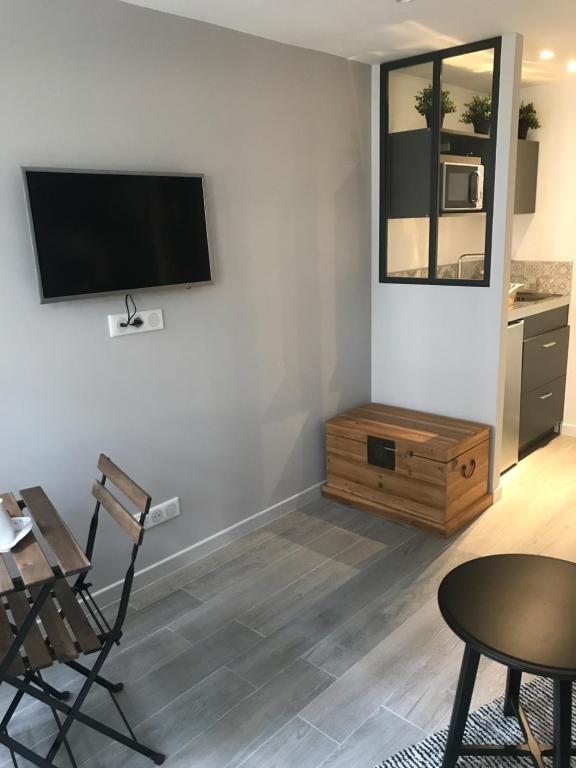 オンフルールにあるLa bonbonnière de Sofiの壁に薄型テレビが取り付けられたリビングルーム