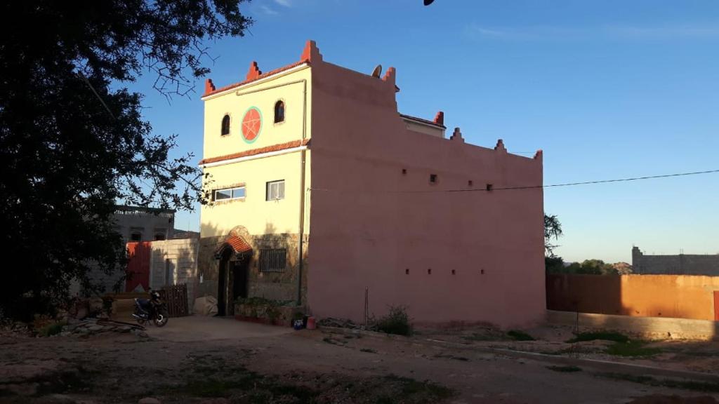 un bâtiment avec une tour d'horloge en haut dans l'établissement Maison d hôtes a Tioute Chez Abdelmajid, à Tiout