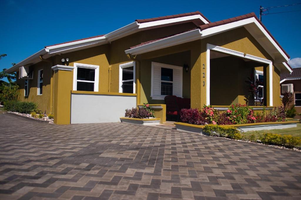 a yellow house with a driveway at Villa Sophia in Mammee Bay