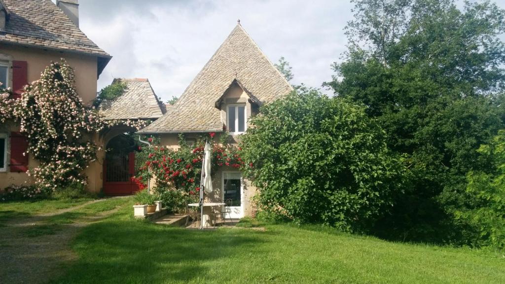 uma casa antiga com um grande jardim de relva em Le Four à Pain em Leynhac