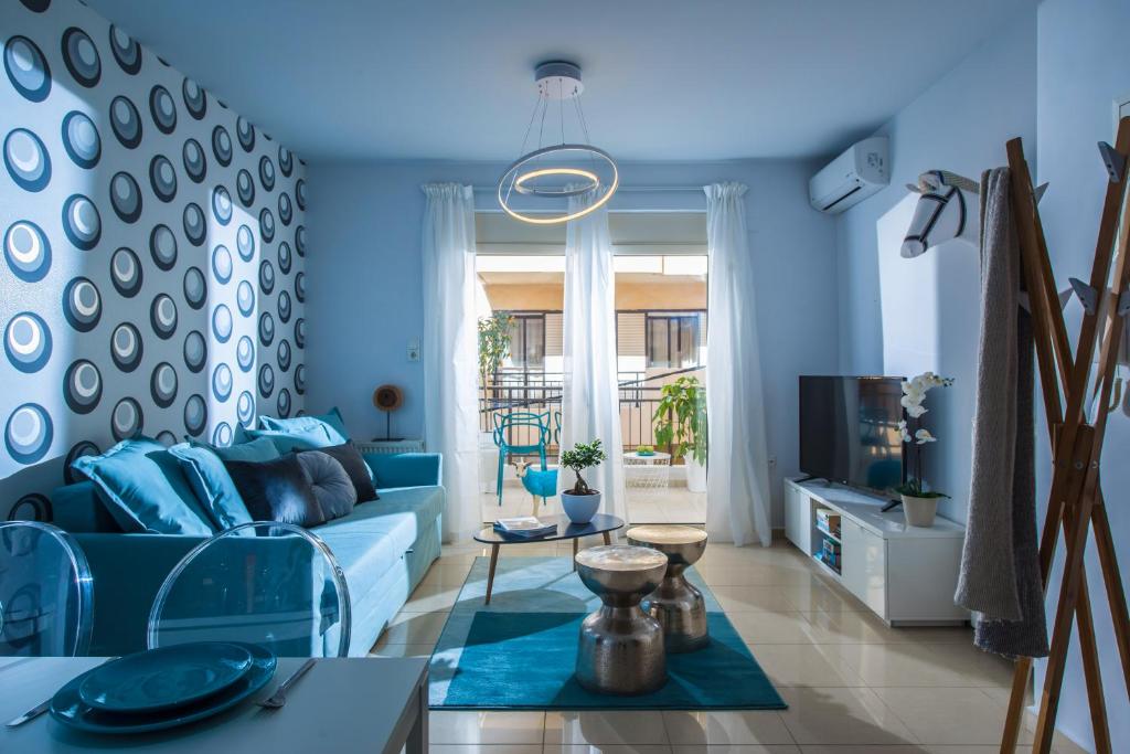 a blue living room with a couch and a tv at Chanion One Suites by Good Life in Heraklio Town