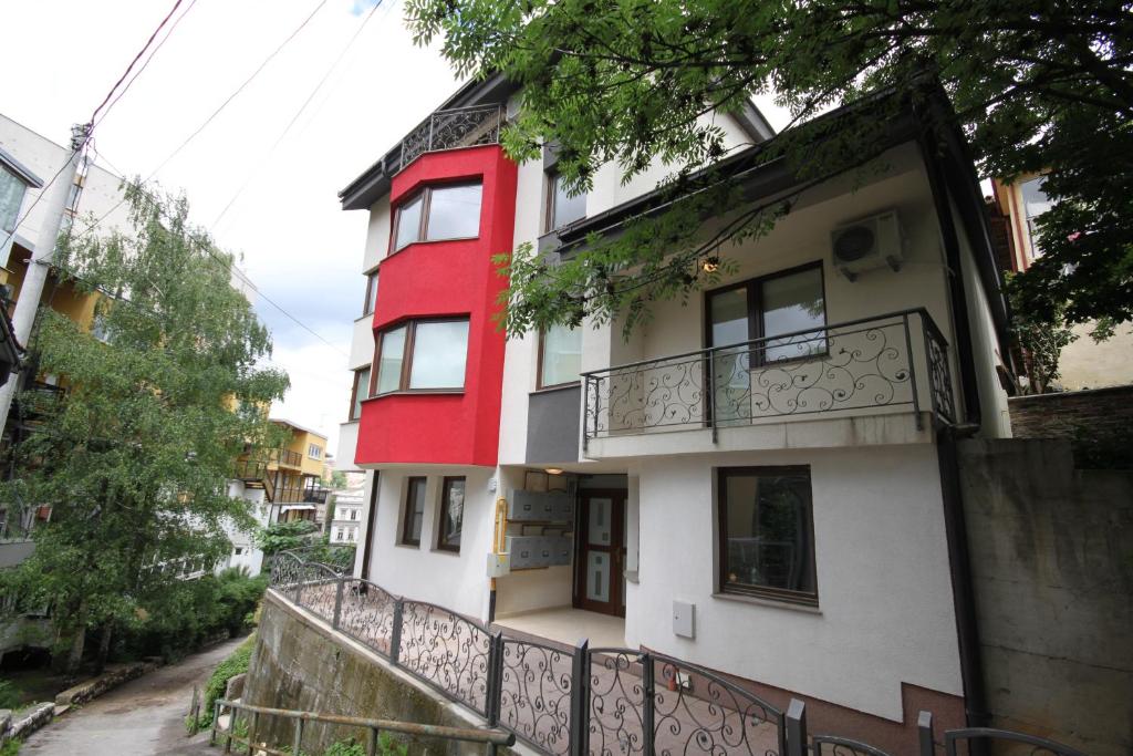 a red and white building with a balcony at Sarajevo Apartments in Sarajevo
