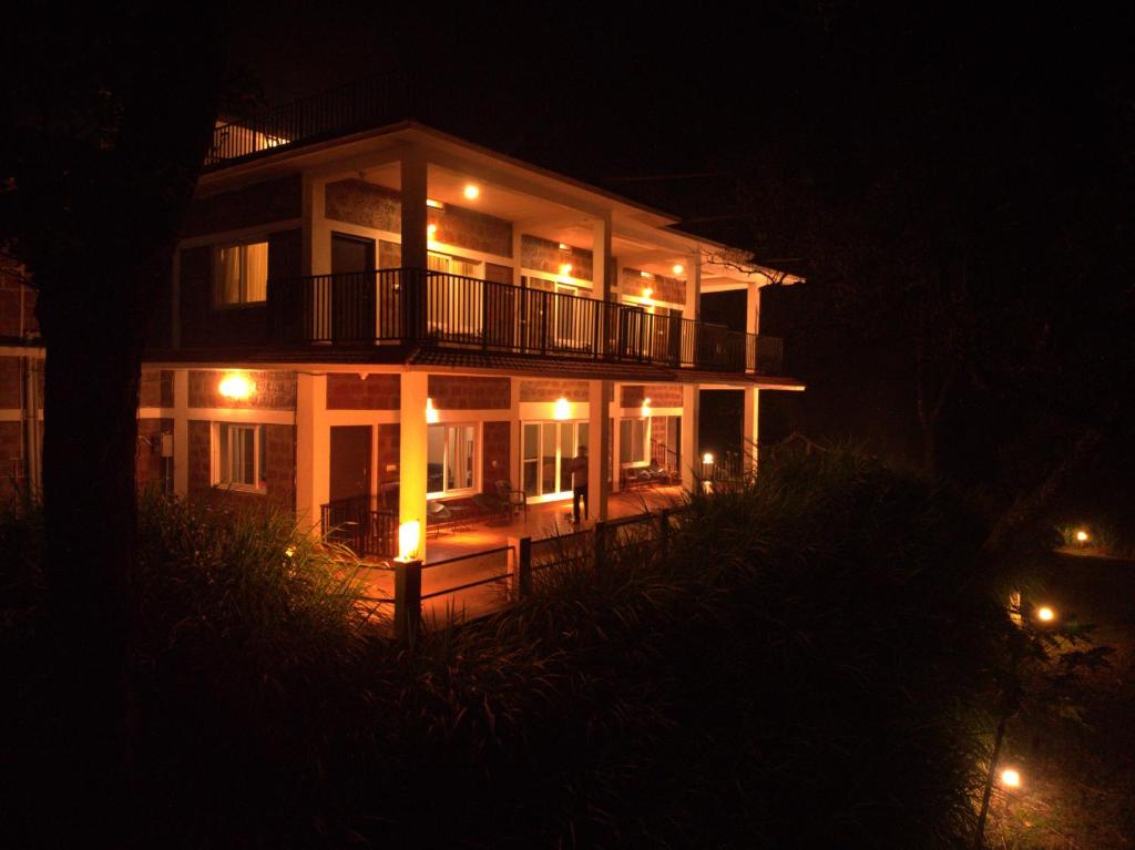 a large house with a balcony at night at Forestdale Coorg in Virajpet