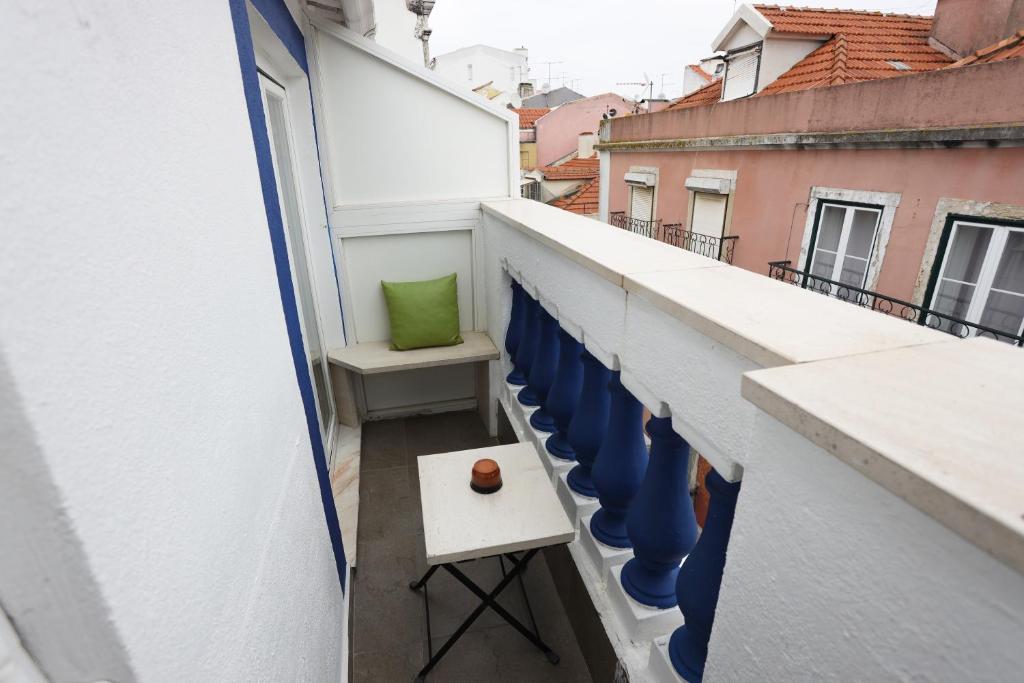 a balcony with blue chairs on a white building at Anjo Azul in Lisbon