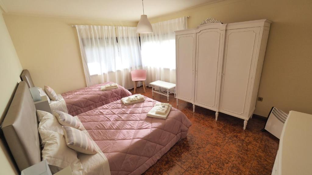 Dormitorio pequeño con cama rosa y armario en Casarão Paraíso en Perafita