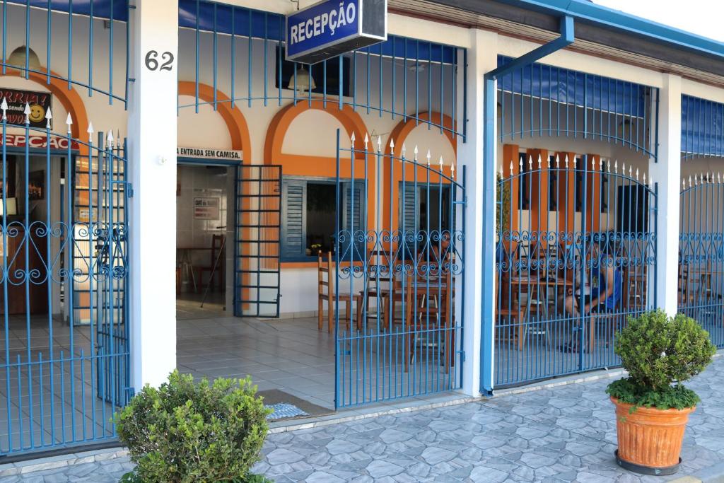 einen Vorraum mit blauen Türen mit Tischen und Stühlen in der Unterkunft Pousada do Marcão in Ubatuba
