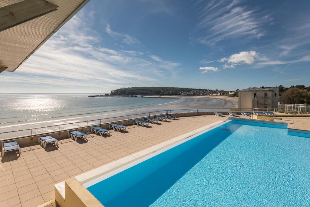 a swimming pool with a view of the beach and the ocean at Résidence Pierre & Vacances Cap-Morgat in Crozon