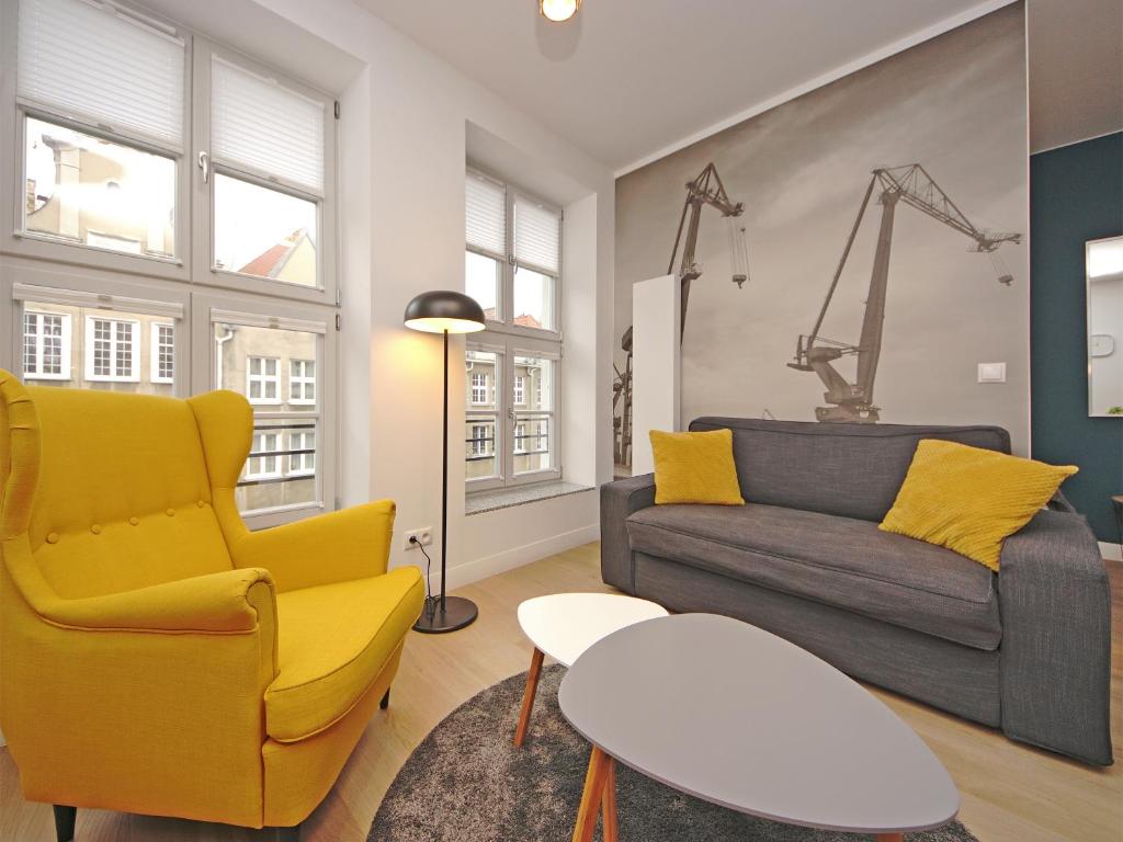 a living room with a couch and a yellow chair at Old Town by Apartmore in Gdańsk