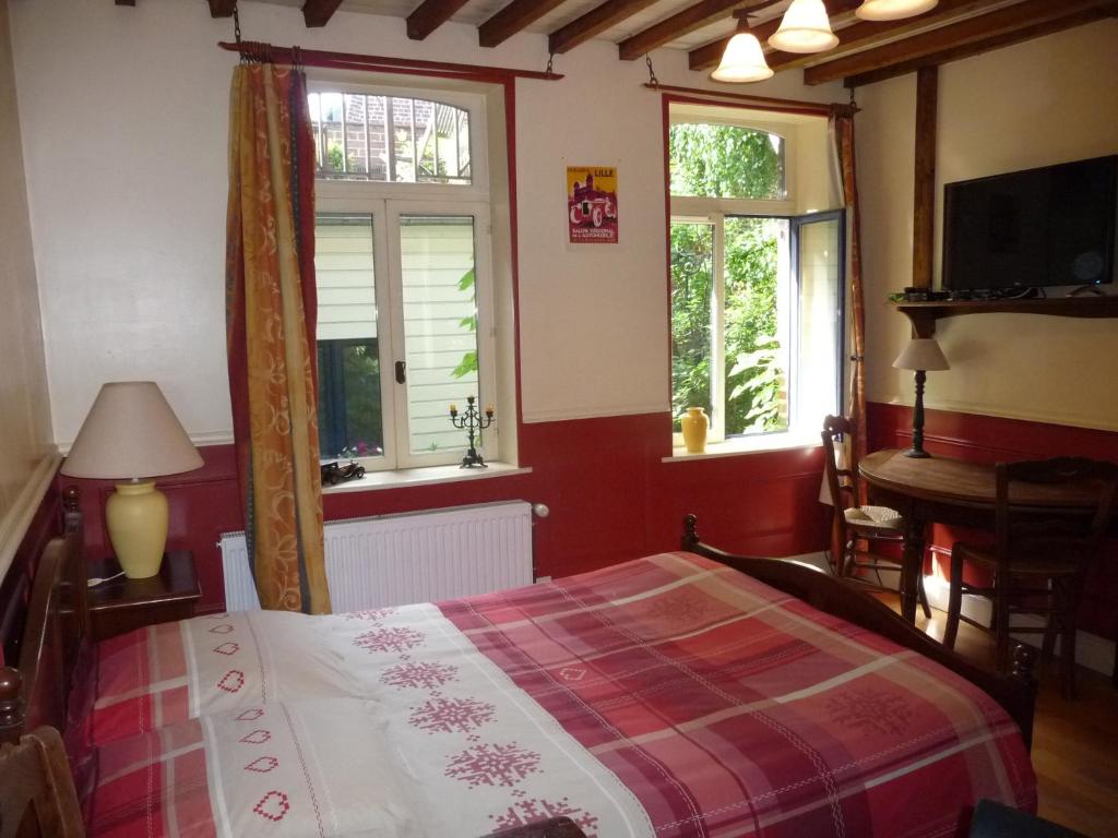 1 dormitorio con 1 cama y 2 ventanas en Chez Christophe, en Lille