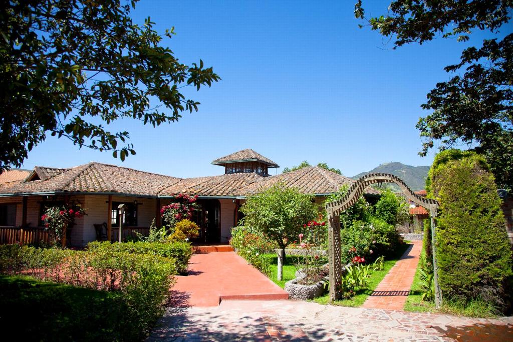 a house with a garden and an arbor at La Quinta San Andrés in Ibarra