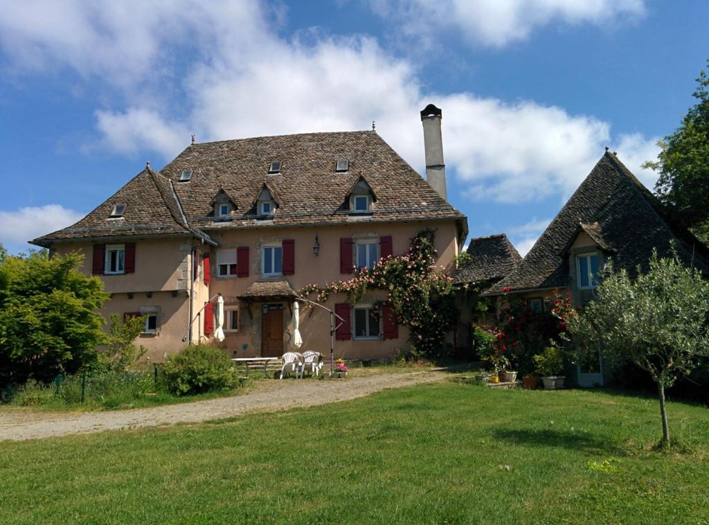 uma casa grande com um jardim de relva em frente em Le Cayla em Leynhac