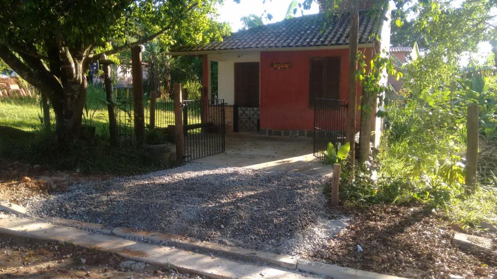 a house with a red door and a fence at Chalézinho - Massaguaçu in Caraguatatuba