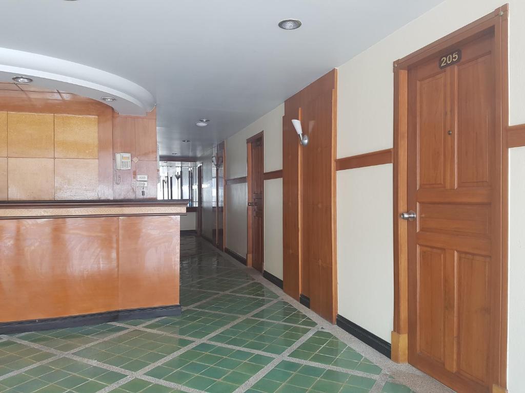 un corridoio vuoto con porte in legno e piastrelle verdi di Phi Phi Hotel a Phi Phi Don