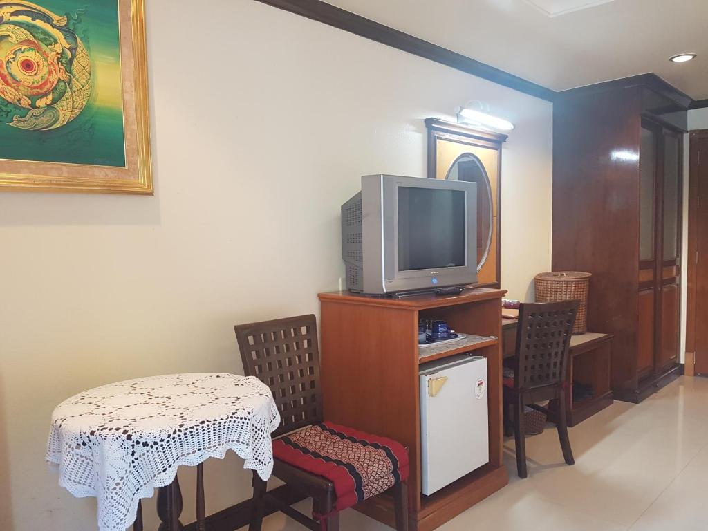 un soggiorno con TV, tavolo e sedie di Phi Phi Hotel a Phi Phi Don