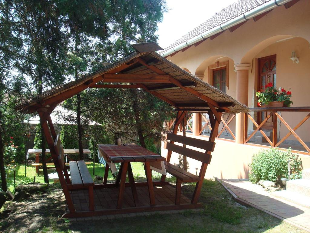 a wooden gazebo in front of a house at Tímea Vendégház in Demjén