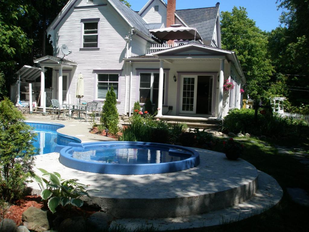 una casa con piscina frente a una casa en Ô Bois Dormant B&B, en Magog-Orford