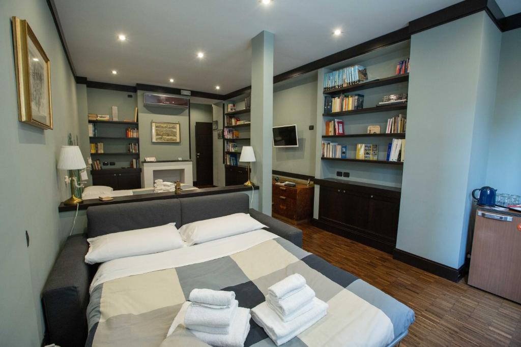 1 dormitorio con 1 cama grande con almohadas blancas en Two Sisters Suites, en Nápoles