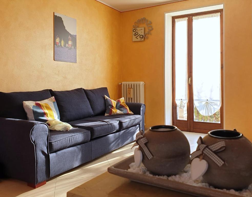 un soggiorno con divano blu e finestra di Casa Genny a Garda