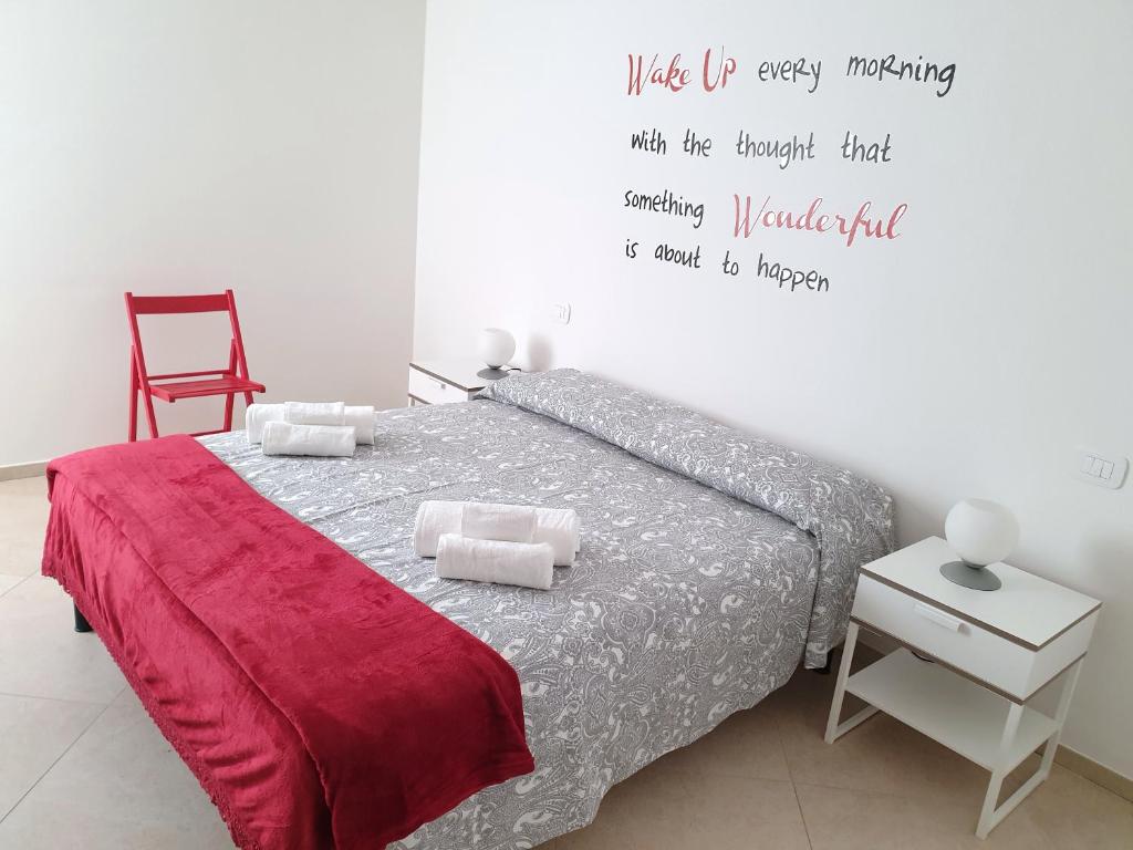 sypialnia z łóżkiem z cytatem na ścianie w obiekcie Casa Genny w mieście Garda