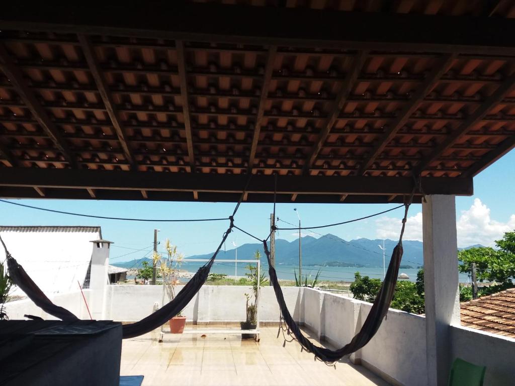 een hangmat op een veranda met uitzicht op de oceaan bij Casa de Pessoas Felizes! in Florianópolis